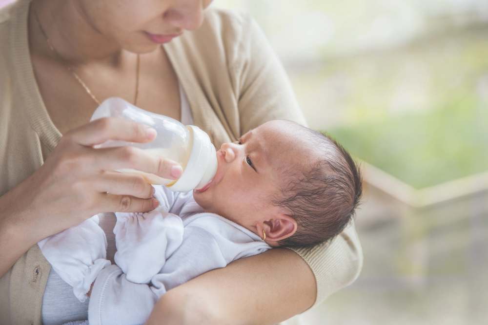 Mother feeding bottle to baby