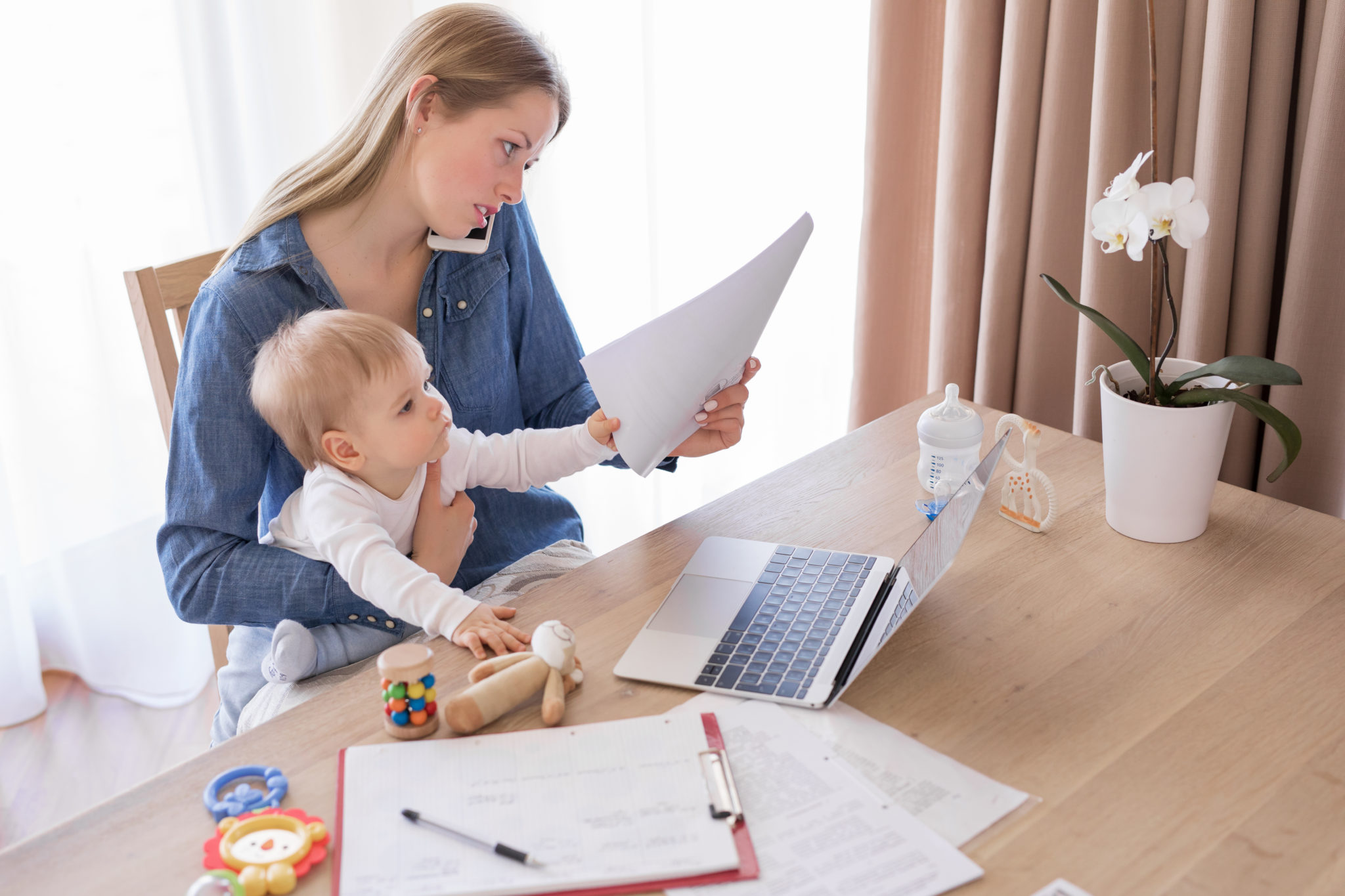 Mom reading papers with baby on lap