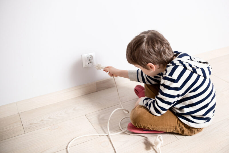 Young child reaching toward electrical outlet